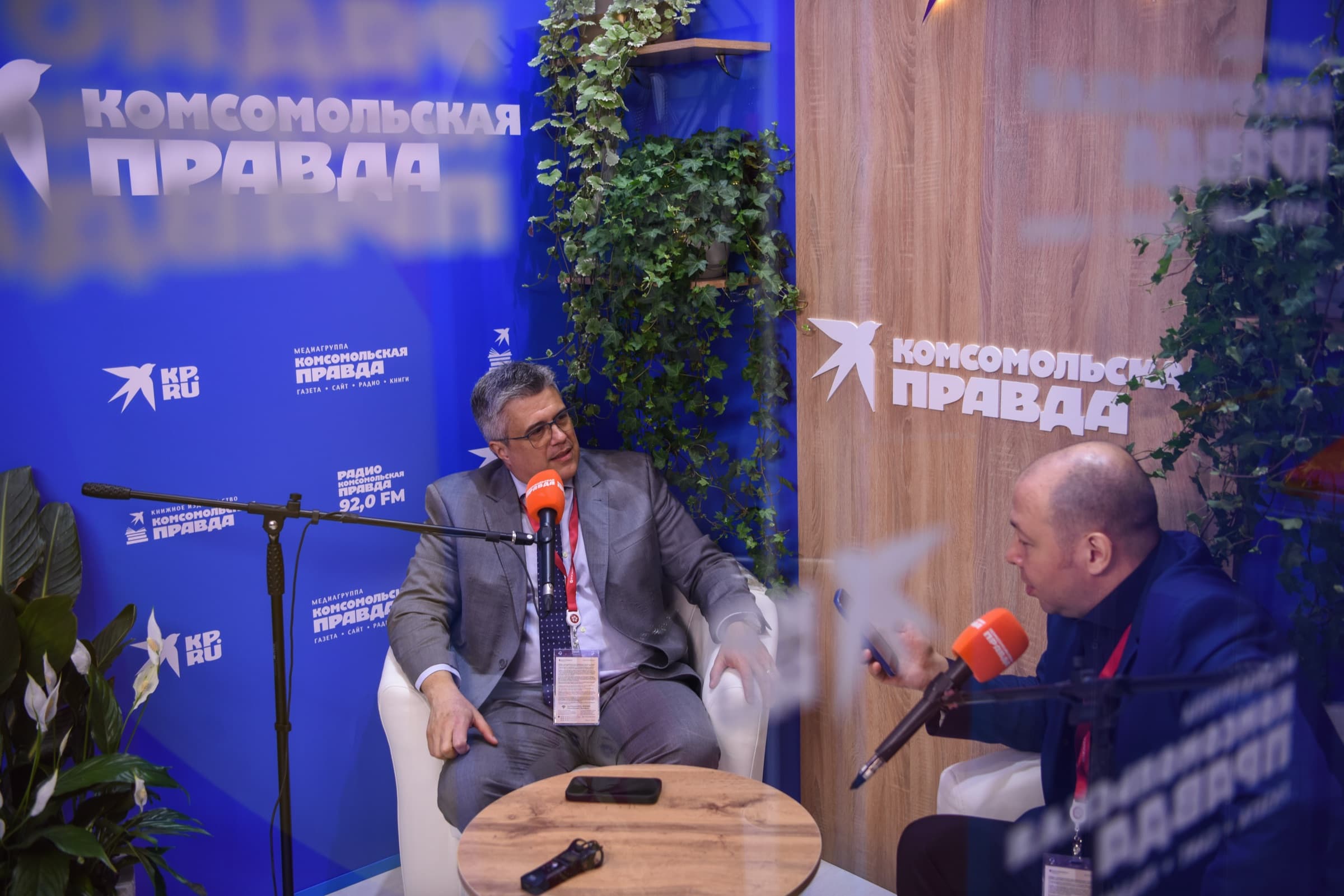 Dr. Alexei Peter concede entrevista sentado em poltrona no estúdio do Komsomolskaya Pravda montado no fórum, diante de microfones.
